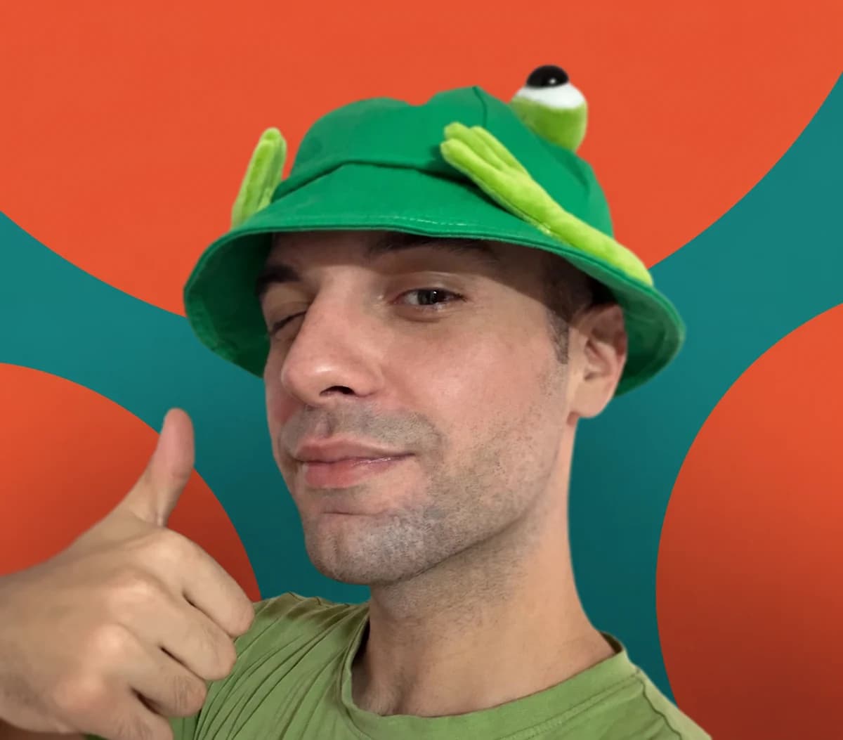 Filip Lazarov wearing a green frog hat and giving a thumbs-up